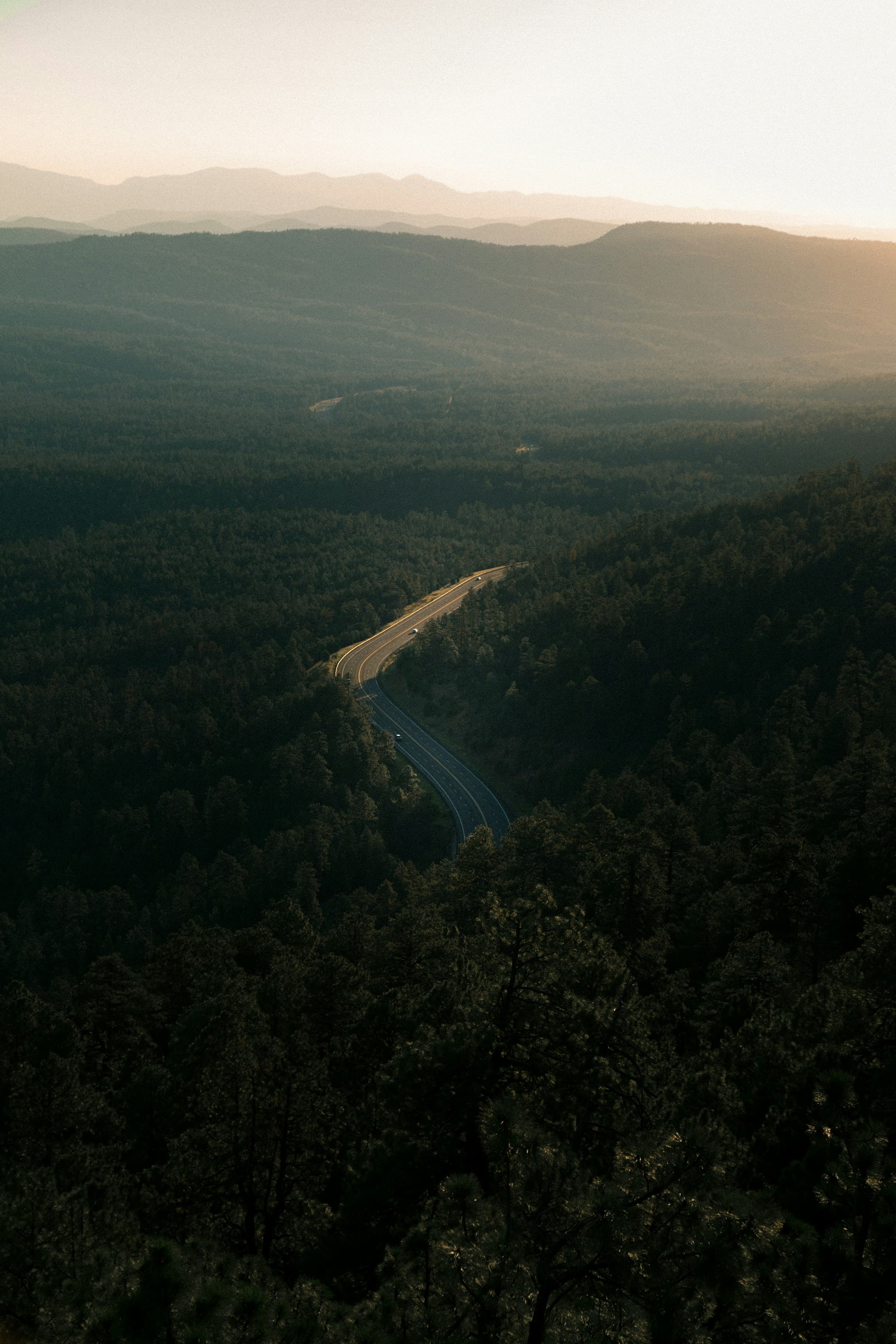 Estrada sinuosa atravessando uma floresta de montanha